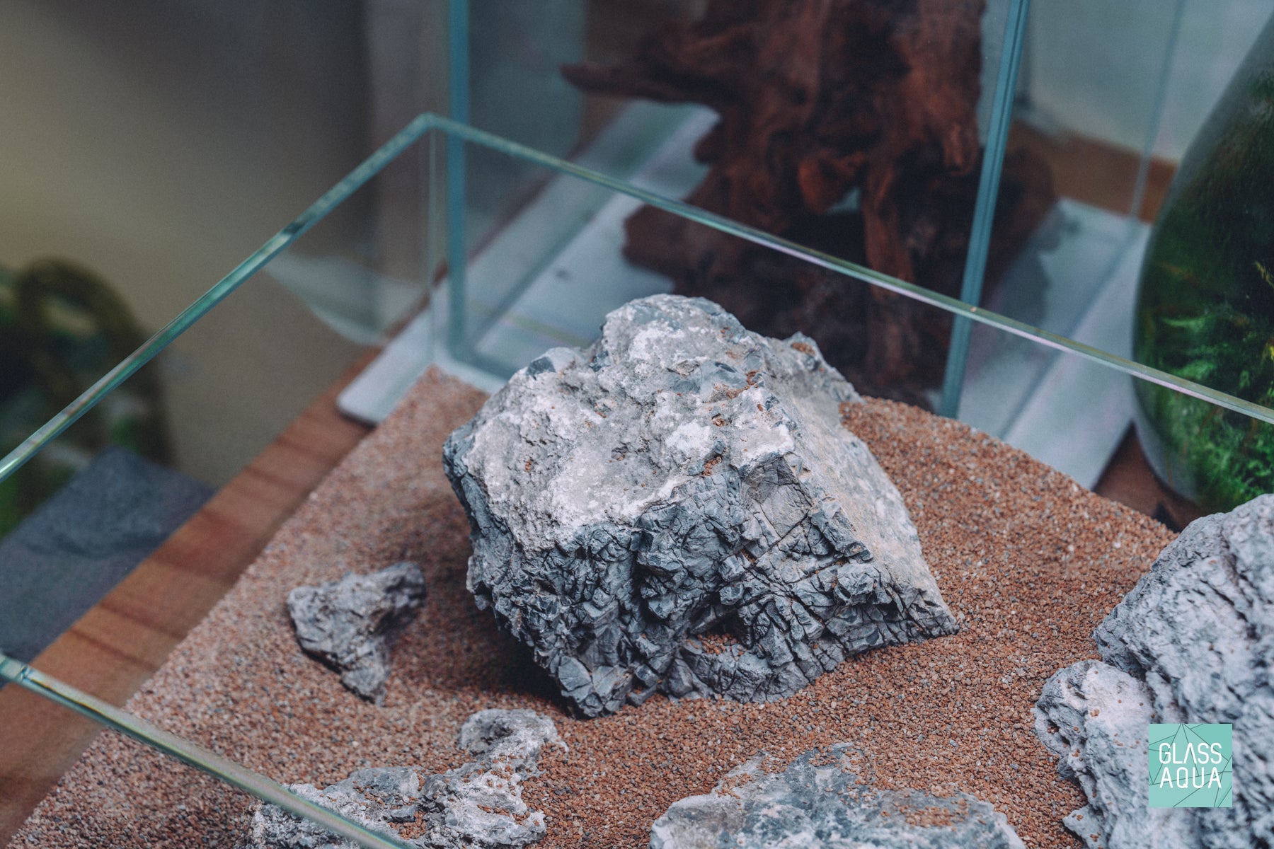 Overhead photo of aquarium stones in UNS 5S rimless aquarium with natural sand